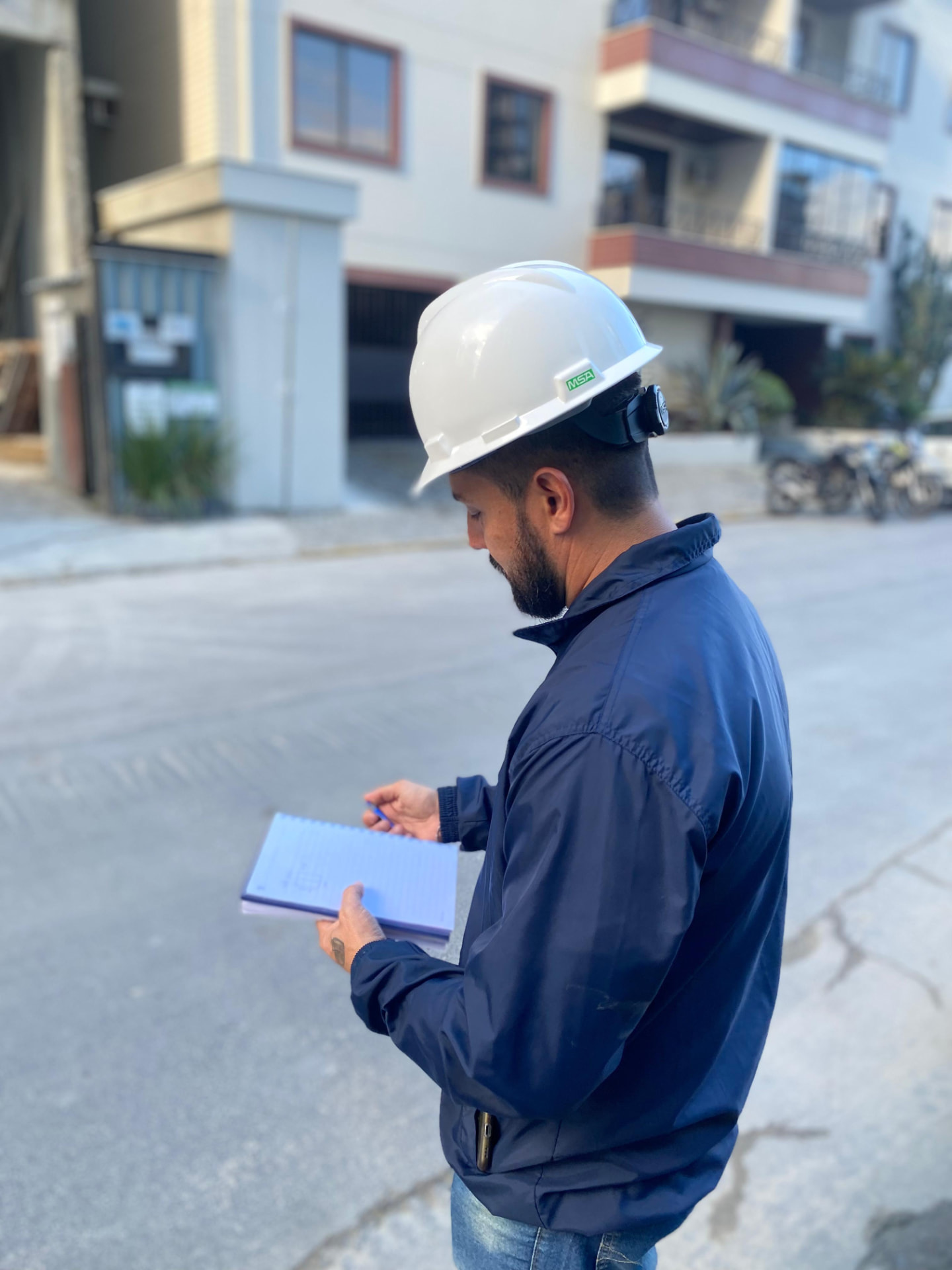 Engenheiro da RC Gestão em obra, conferindo projeto com capacete